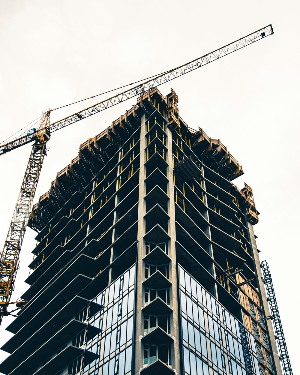A high-rise under construction beside a tower crane