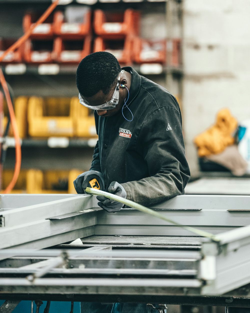 A technician grinding metal on a factory floor